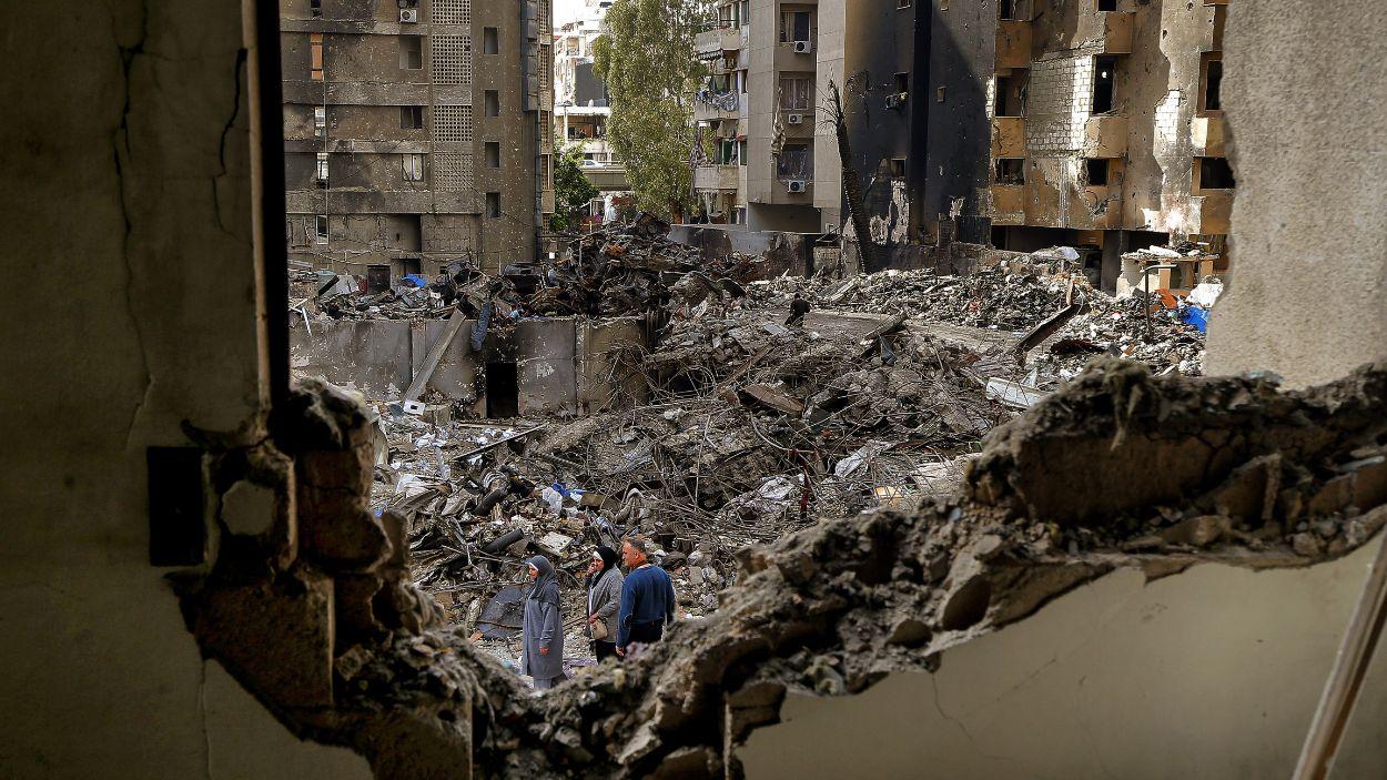 Ciudadanos libaneses caminando entre escombros en Beirut tras un ataque israelí. EP.