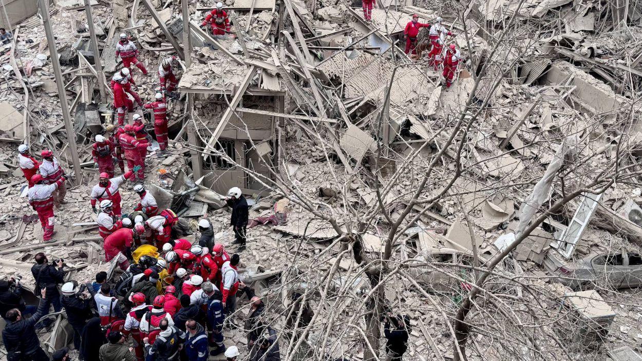 Equipos de rescate de la Sociedad de la Media Luna Roja Iraní (IRCS) trabajan en el lugar de un edificio destruido por un ataque aéreo en Teherán.