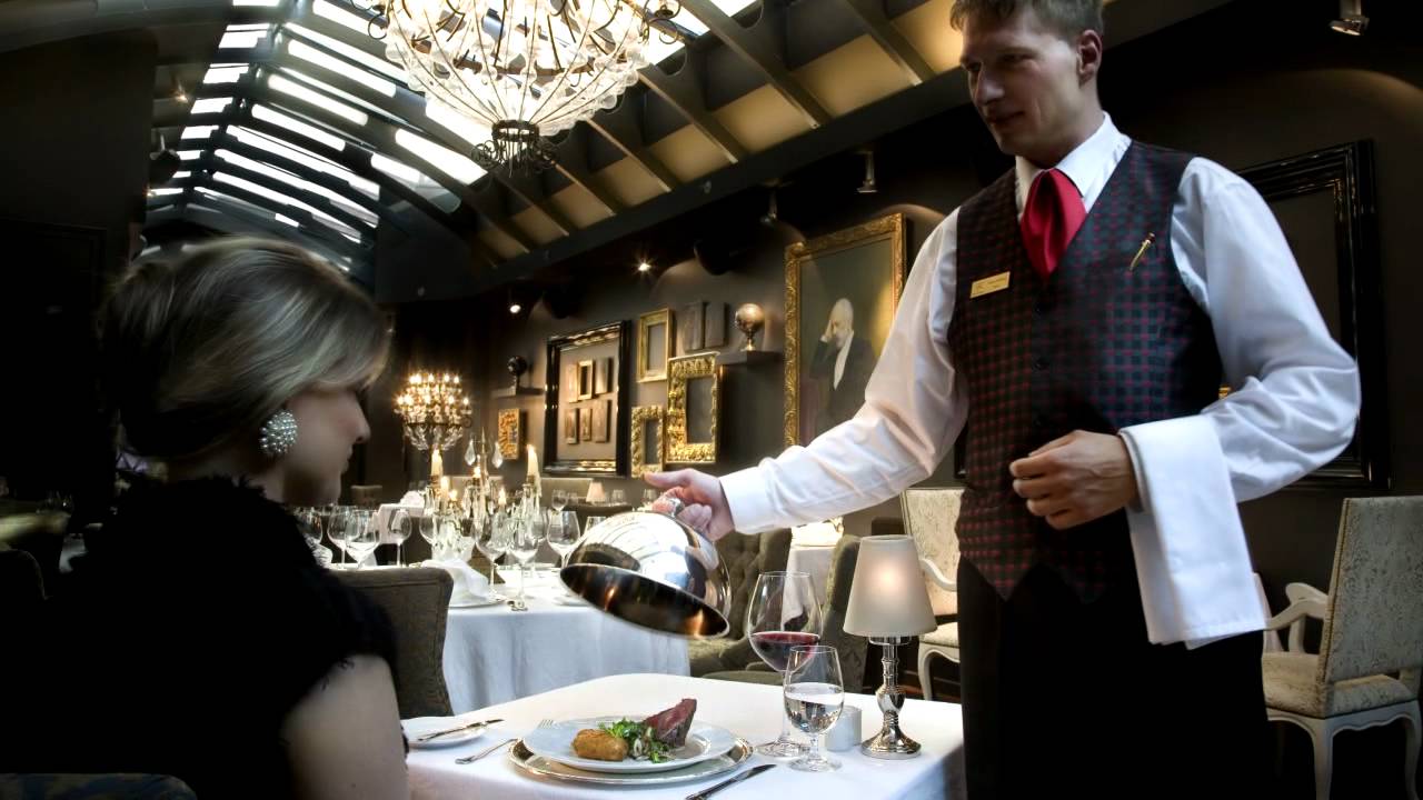 Un camarero atiende clientes en un restaurante