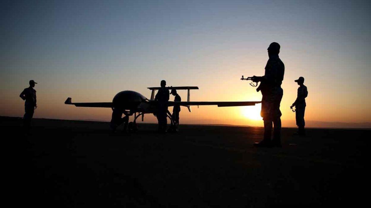 Técnicos iraníes se acercan a un vehículo aéreo no tripulado militar en una pista durante un ejercicio con drones . EP/Archivo.