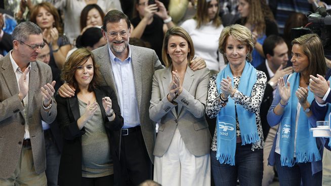 Mariano Rajoy abrazando a Soraya Sáenz de Santamaría y Dolores de Cospedal, en un acto del PP