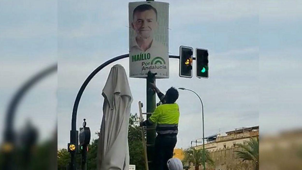 Operarios municipales de Sevilla retirando carteles electorales de Por Andalucía / Por Andalucía