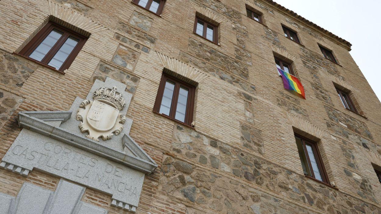 La bandera LGTBI cuelga de la fachada de las Cortes regionales de Castilla La Mancha. Cortes.
