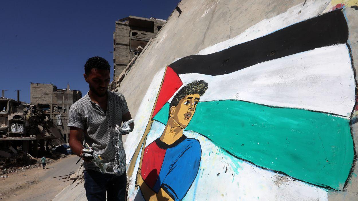 Un artista gazatí pinta un mural del futbolista Lamine Yamal con la bandera de Palestina. EP.