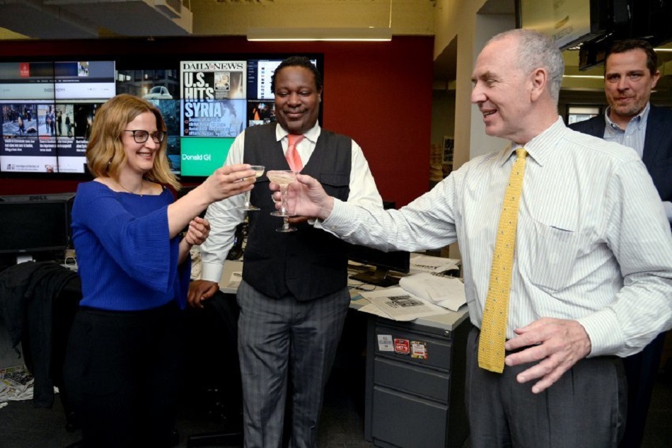 Fotografía cedida por el New York Daily News de la reportera Sarah Ryley (i) brindando por su Premio Pulitzer en la categoría de Servicio Público, junto al jefe de noticias Robert Moore