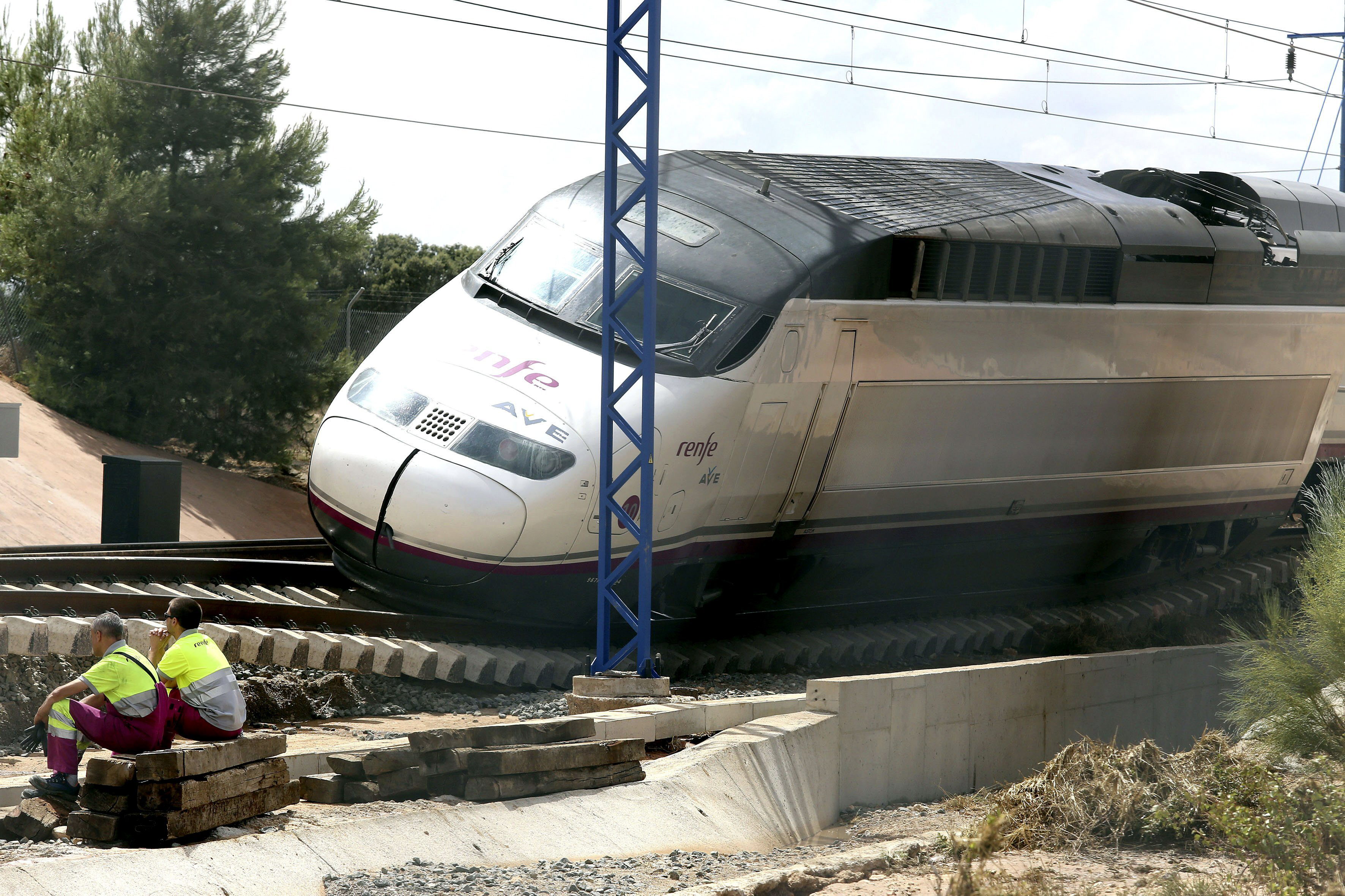 Operarios junto un tren en la línea de AVE Madrid-Alicante
