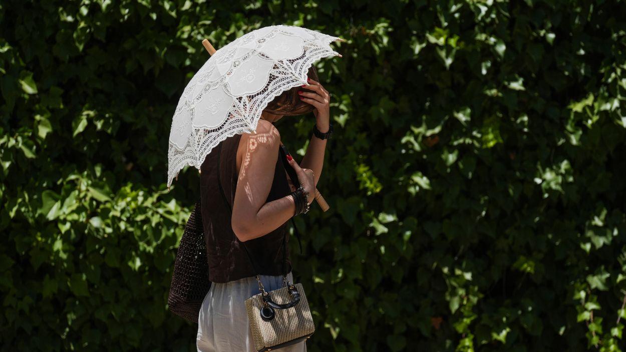 Turistas se protegen del calor por las calles de Sevilla, a 27 de mayo de 2026. EP.