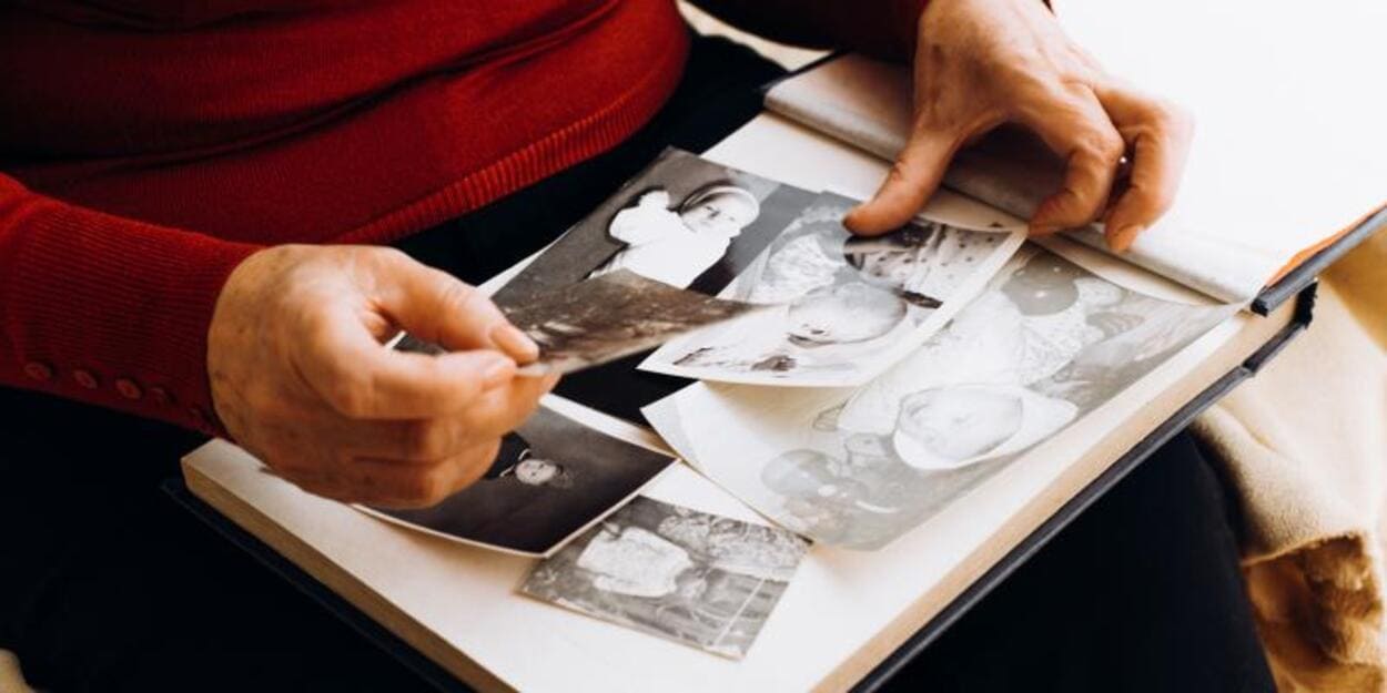 Persona contemplando fotos familiares. © Shutterstock. Sergio Photone