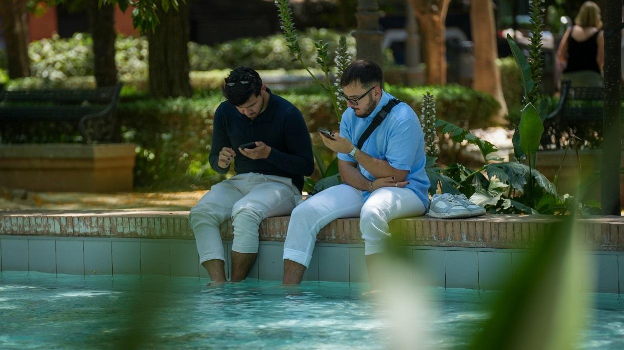 Personas en las calles de Sevilla, buscando sombra y agua ante las altas temperaturas. EP