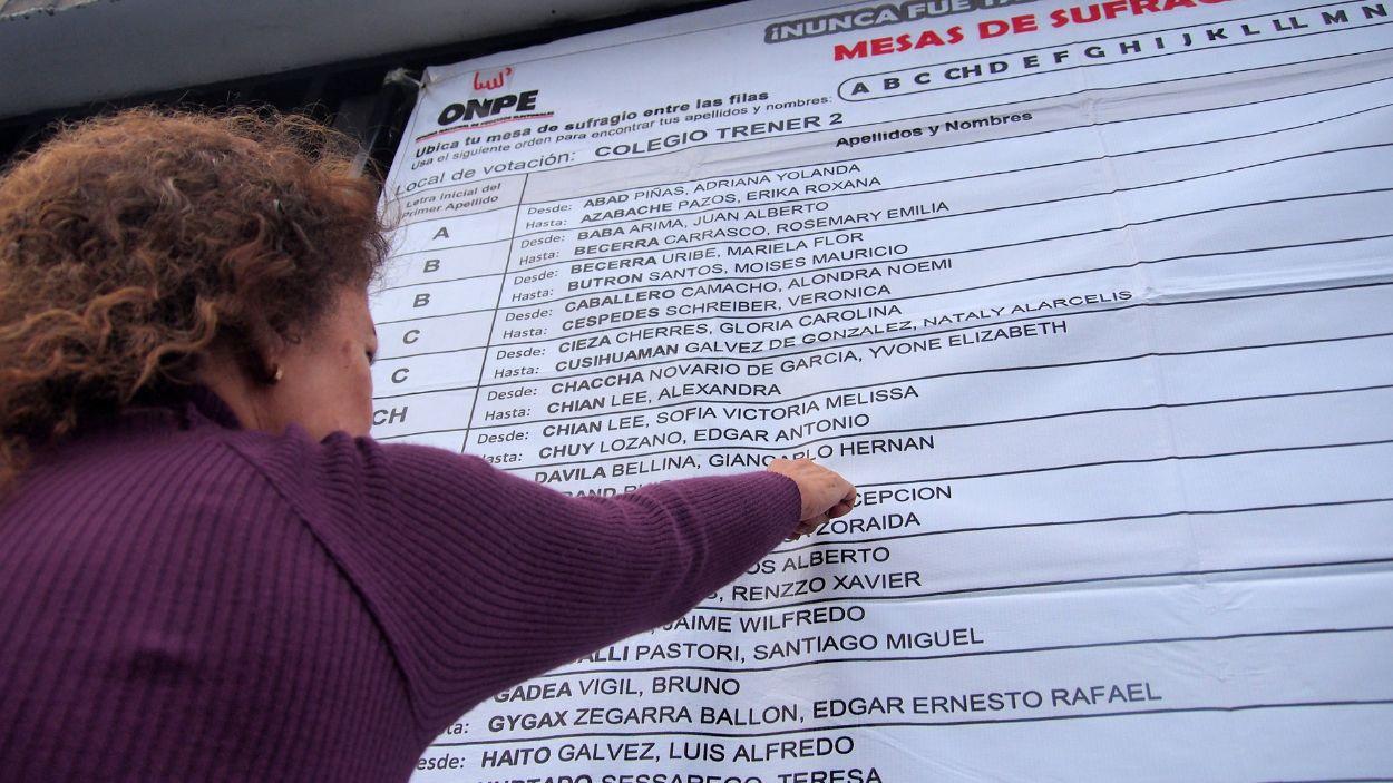 Una mujer busca su centro de votación según su apellido en un colegio electoral. EP.