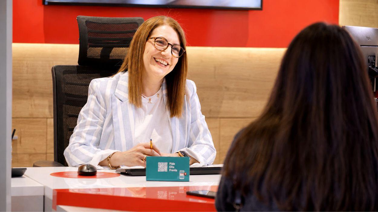 Una agente de Santander atiende a una clienta ©Santander
