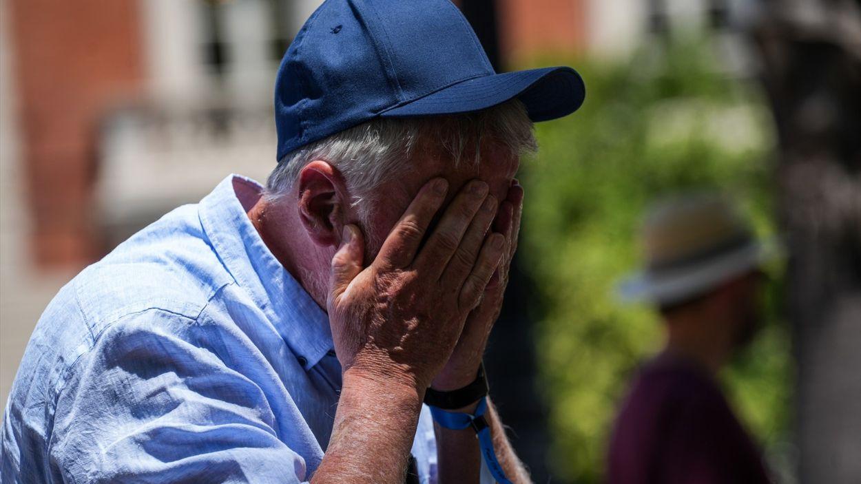 Un señor trata de combatir la calor en Sevilla refrescándose la cara con agua / EP
