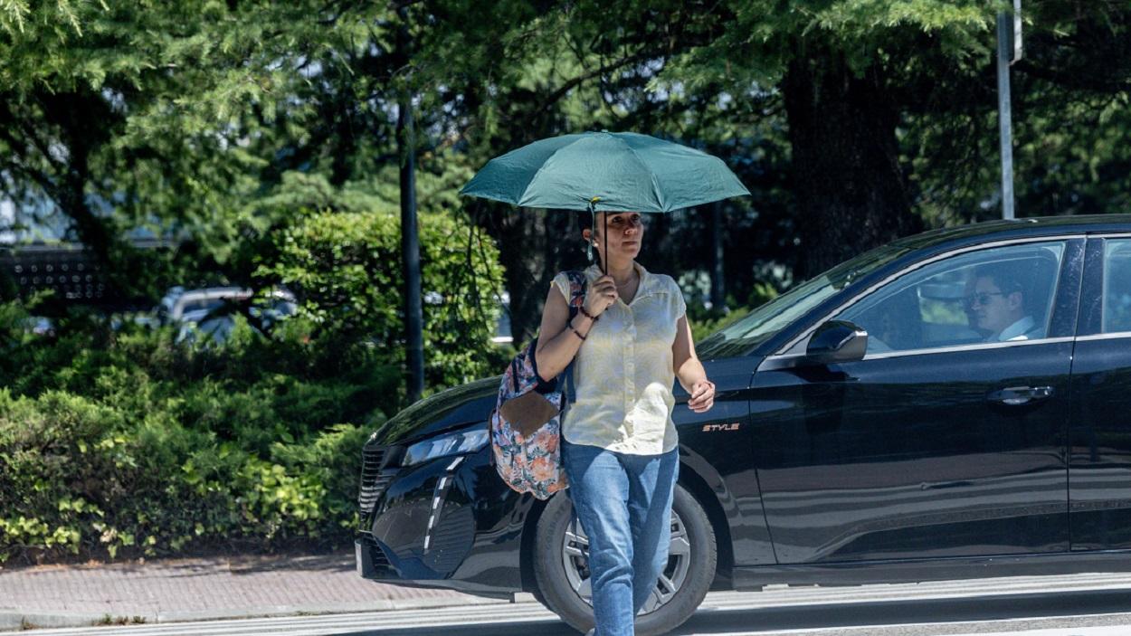 Una persona con paraguas para protegerse del calor en Madrid. EP