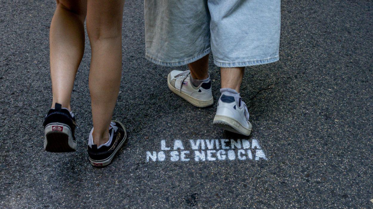 Manifestantes sobre pintada en el suelo con lema 'La vivienda no se negocia' durante una manifestación en defensa del derecho al acceso a la vivienda, a 24 de mayo de 2026, Madrid. EP.