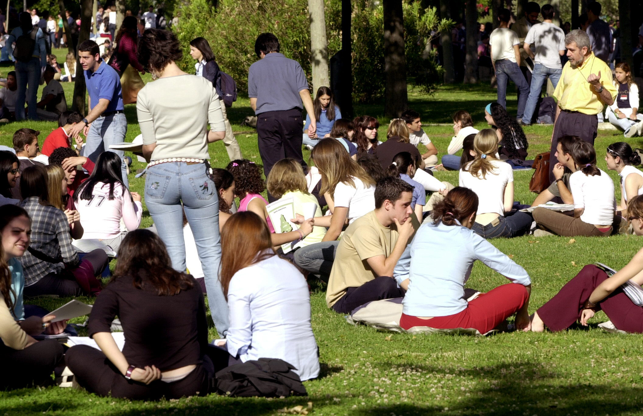 Estudiantes en el césped en el campus universitario