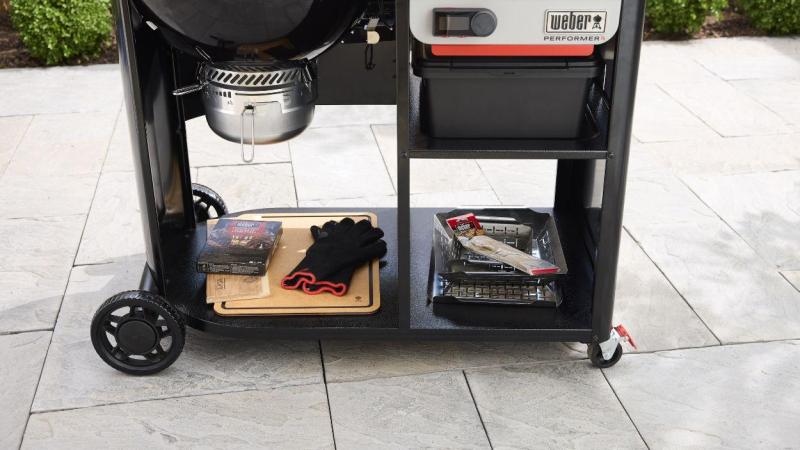 Los dos estantes de almacenamiento del modelo Premium Smart mantienen todo a mano: tablero de corte, guantes, virutas de madera para ahumar. Nada fuera de lugar.