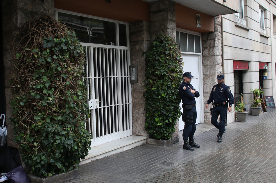Una pareja de policías vigila la entrada del edificio de Barcelona donde se encuentra la vivienda del expresidente de la Generalitat Jordi Pujol. 