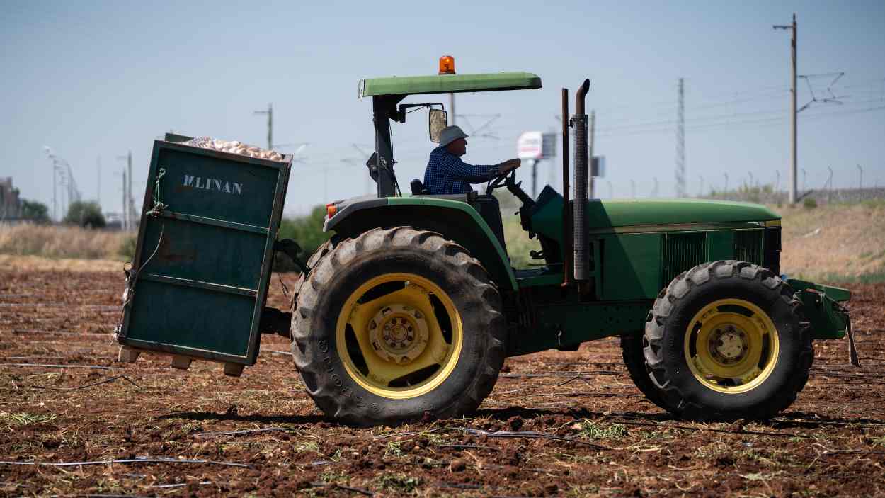 Imagen de archivo de un agricultor montado en un tractor en una explotación agraria. EP.
