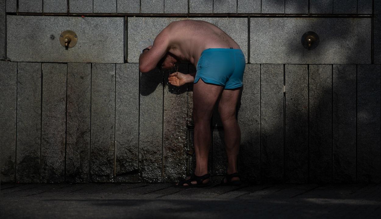 Una persona se refresca en una fuente, en Madrid Río, a 23 de junio de 2026, en Madrid. EP