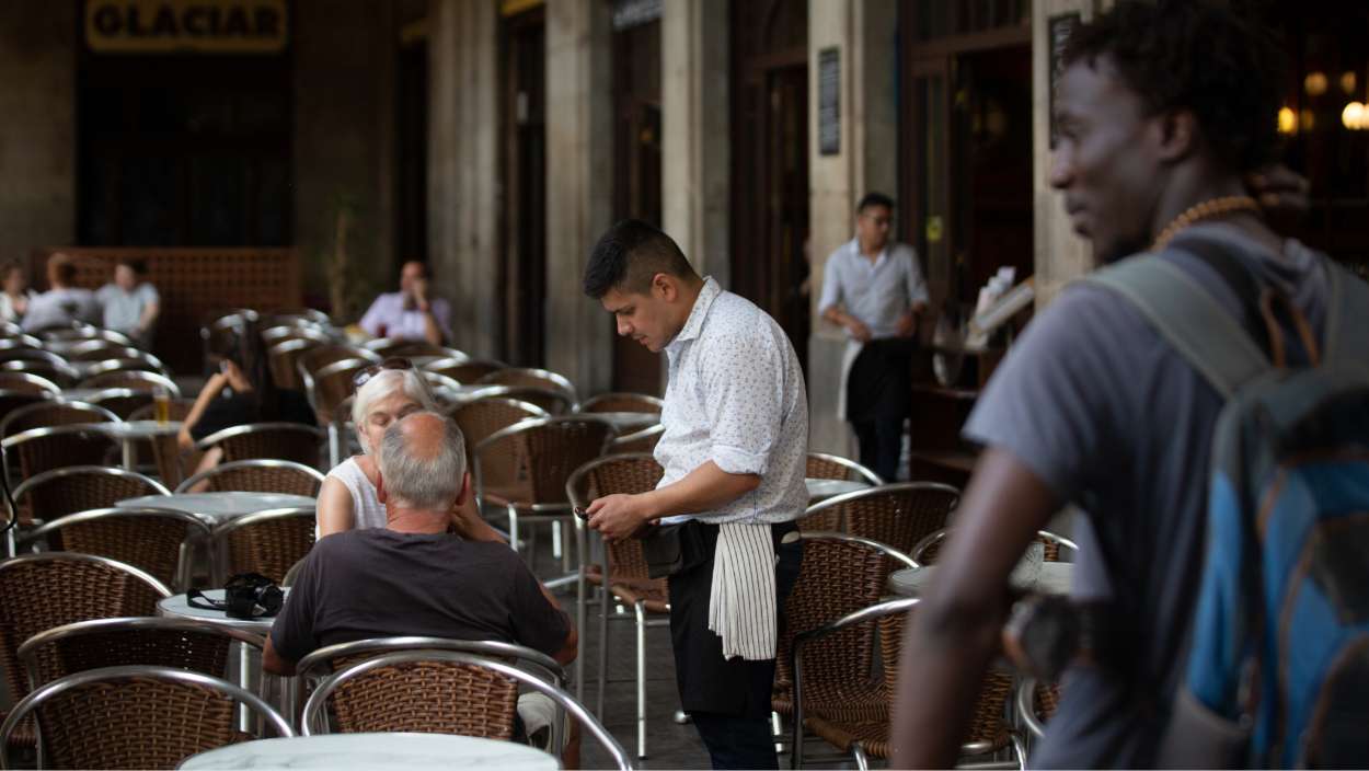 Un camarero atiende a una mesa en la plaza Real de Barcelona, a 15 de junio de 2022. David Zorrakino / EP
