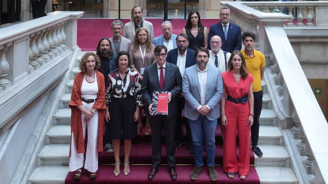 El presidente de la Generalitat, Salvador Illa, con representantes de ERC y de los Comuns y representantes de los agentes sociales en la escalera de honor del Parlament tras la aprobación de los presupuestos. David Zorrakino / EP