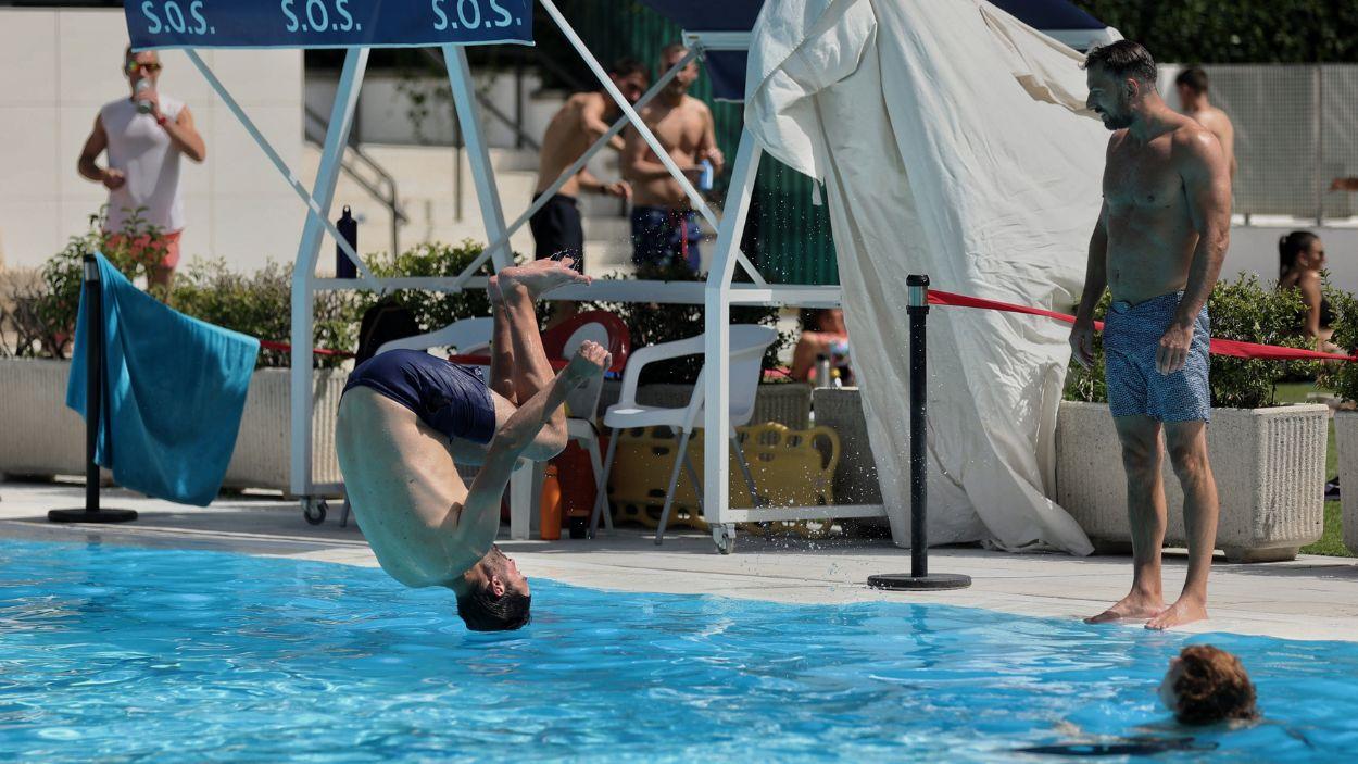 Un hombre se tira de cabeza al agua en la piscina municipal de Casa de Campo, a 17 de junio de 2022, en Madrid, (España)
