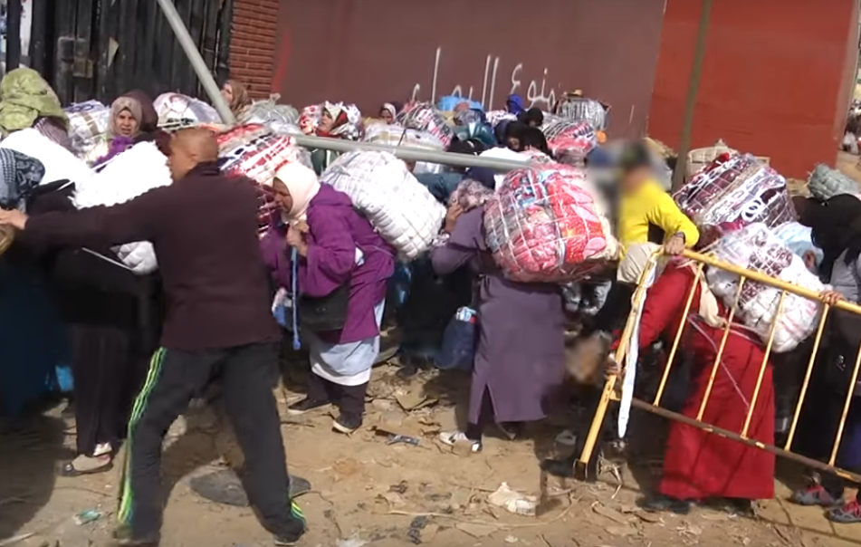 Con decenas de kilos a sus espaldas, las porteadoras esperan horas a que se abra el paso de la frontera.