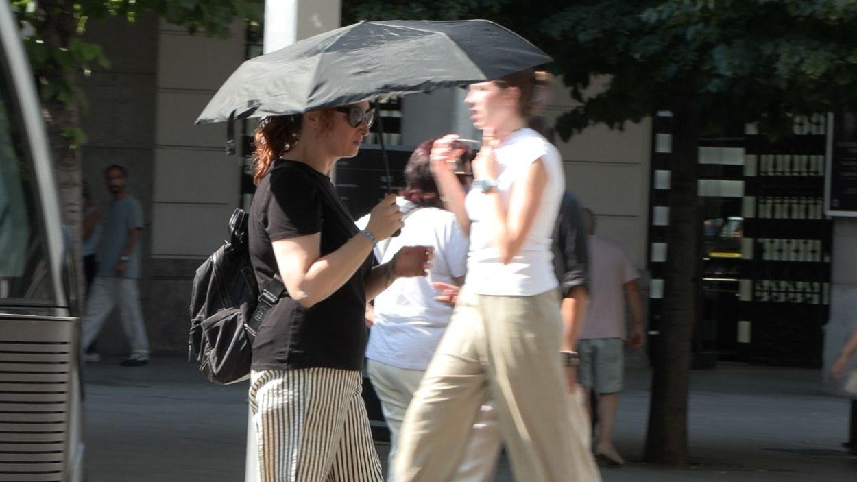Mujer con paraguas para refugiarse del sol, en Zaragoza. EP.