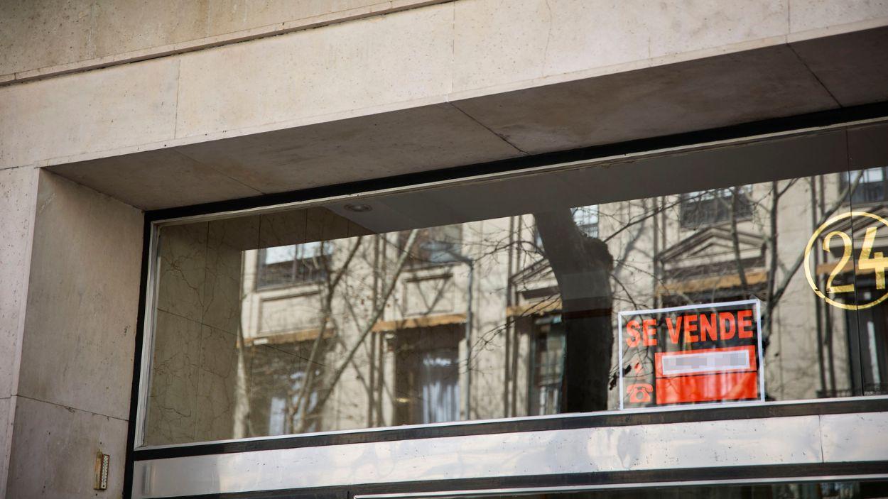 Un cartel que anuncia la venta de una vivienda en la fachada de un edificio. EP.
