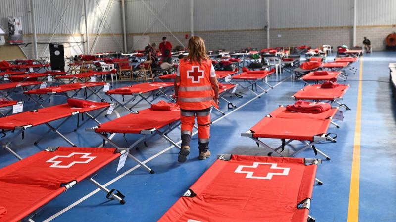 Los Servicios de Emergencias despliegan camas para las personas desalojadas en un pabellón deportivo en Humanes. EP.