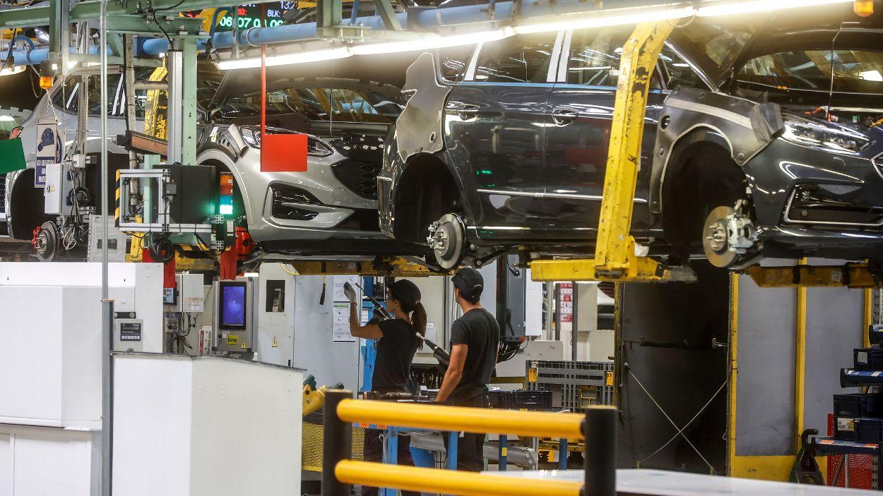 Dos trabajadores con un vehículo en la fábrica de Ford en Almussafes. EP/Archivo.