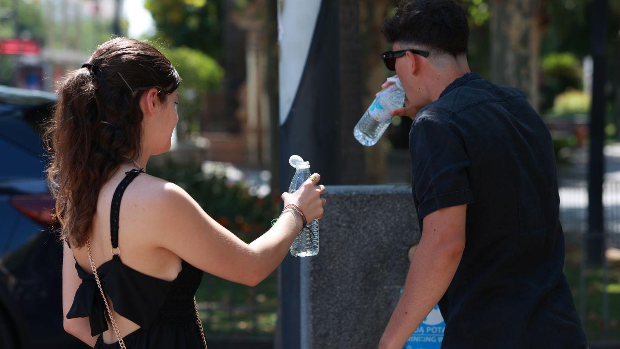 Una pareja bebe agua durante la ola de calor. A 05 de julio de 2026, en Sevilla. EP.