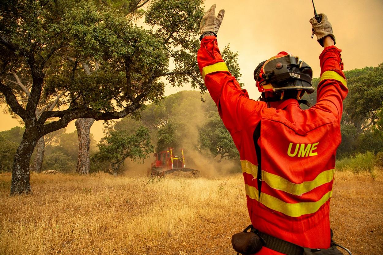 Agente de la UME da instrucciones al bulldozer que trabaja en los Incendios de Pinar de Almorox (Toledo). Tamara Rozas