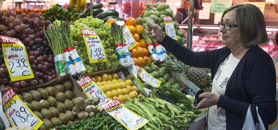 En la imagen, una mujer hace su compra en una frutería del mercado Maravilla en Madrid