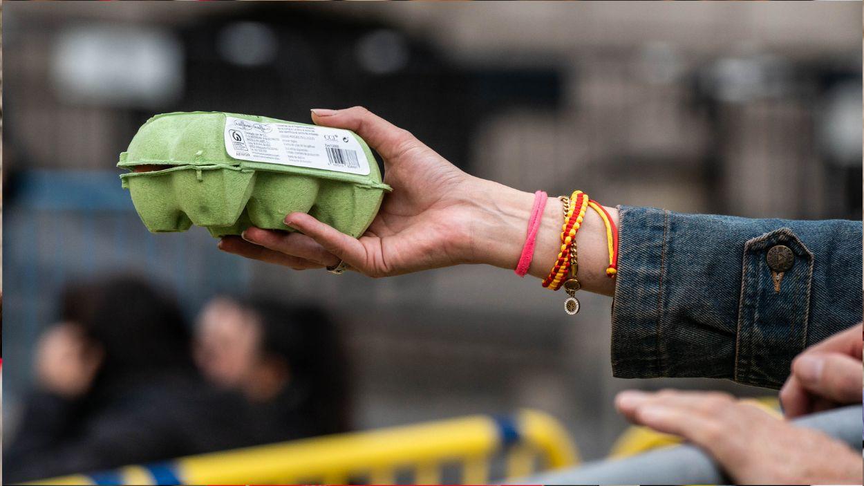 Una manifestante le ofrece un paquete de huevos a la Policía durante una manifestación contra la investidura de Pedro Sánchez el día en que se celebra en el Congreso de los Diputados el pleno en el que se le nombrará de nuevo presidente, a 15 de noviembre de 2023, en Madrid (España). EP.