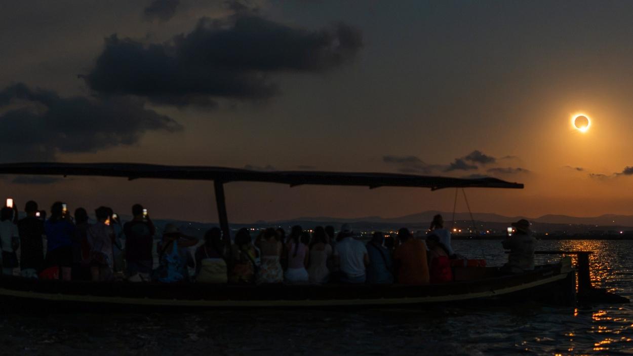 Varias personas en un barco durante el eclipse solar total de 2026, a 12 de agosto de 2026, en Valencia. EP.