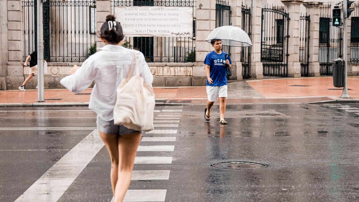 Varias personas pasean bajo la lluvia, a 25 de junio de 2026, en Madrid. EP.