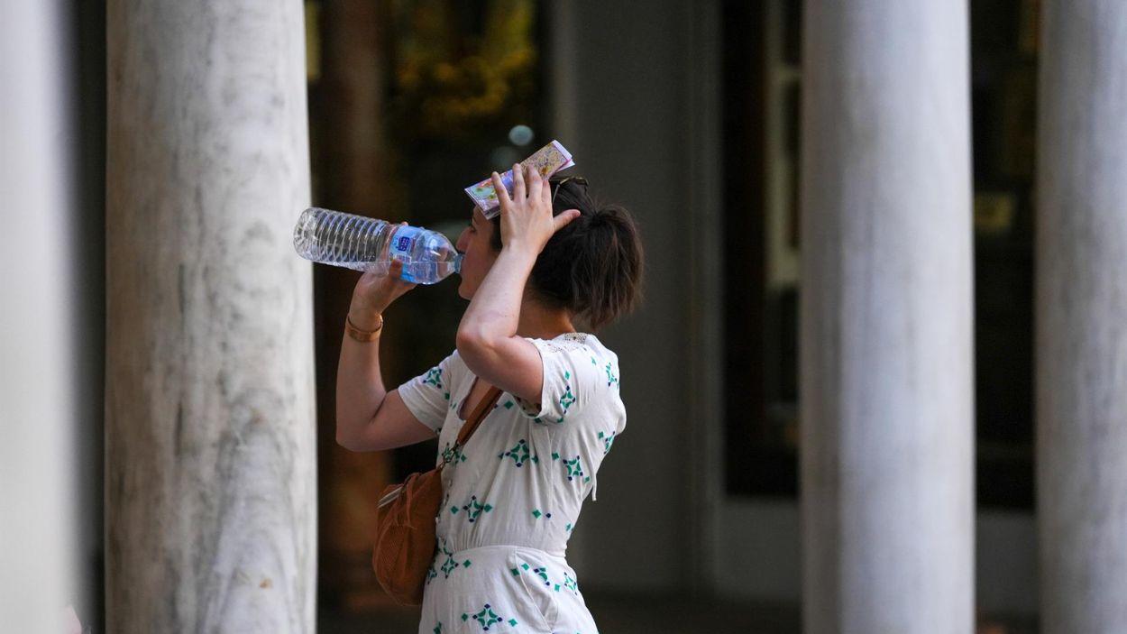 Una mujer bebiendo agua mientras pasea por Sevilla. Europa Press.