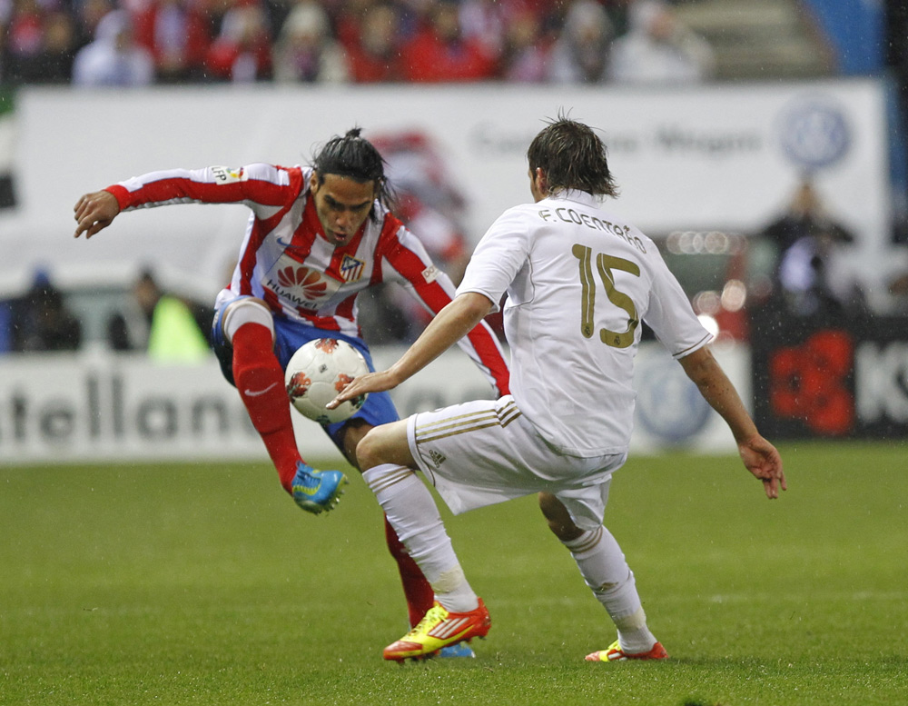 El jugador del Real Madrid, el portugués Fabio Coentrao (d) y el exjugador del Atlético de Madrid, el colombiano Radamel Falcao (i)