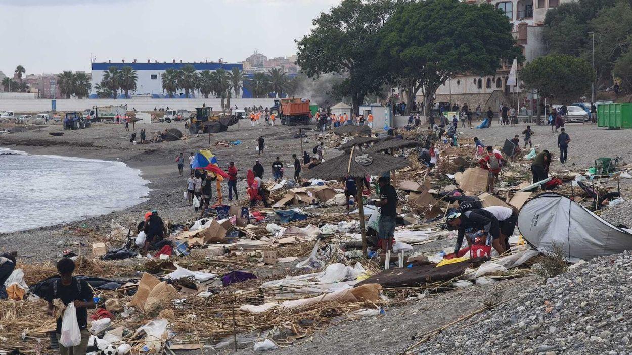 Varias personas recogen sus pertenencias del asentamiento improvisado de la playa del Trampolín. EP.
