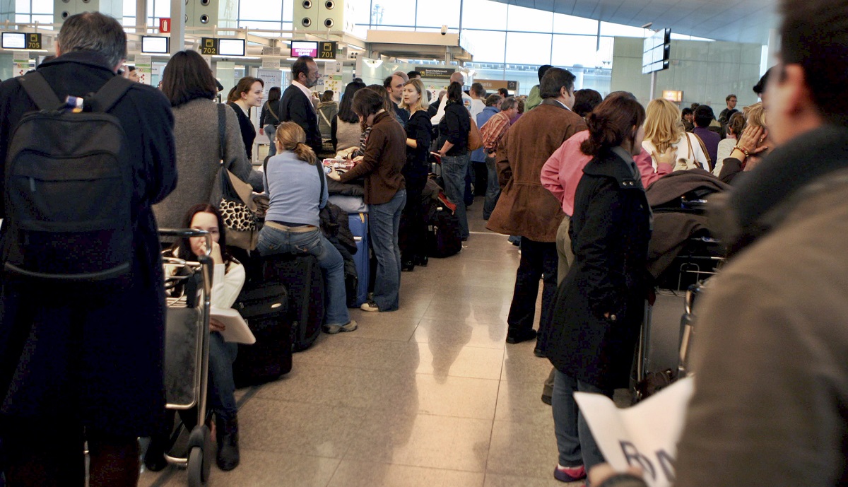 Varios pasajeros hacen cola en el aeropuerto del Prat de Llobregat (Barcelona)