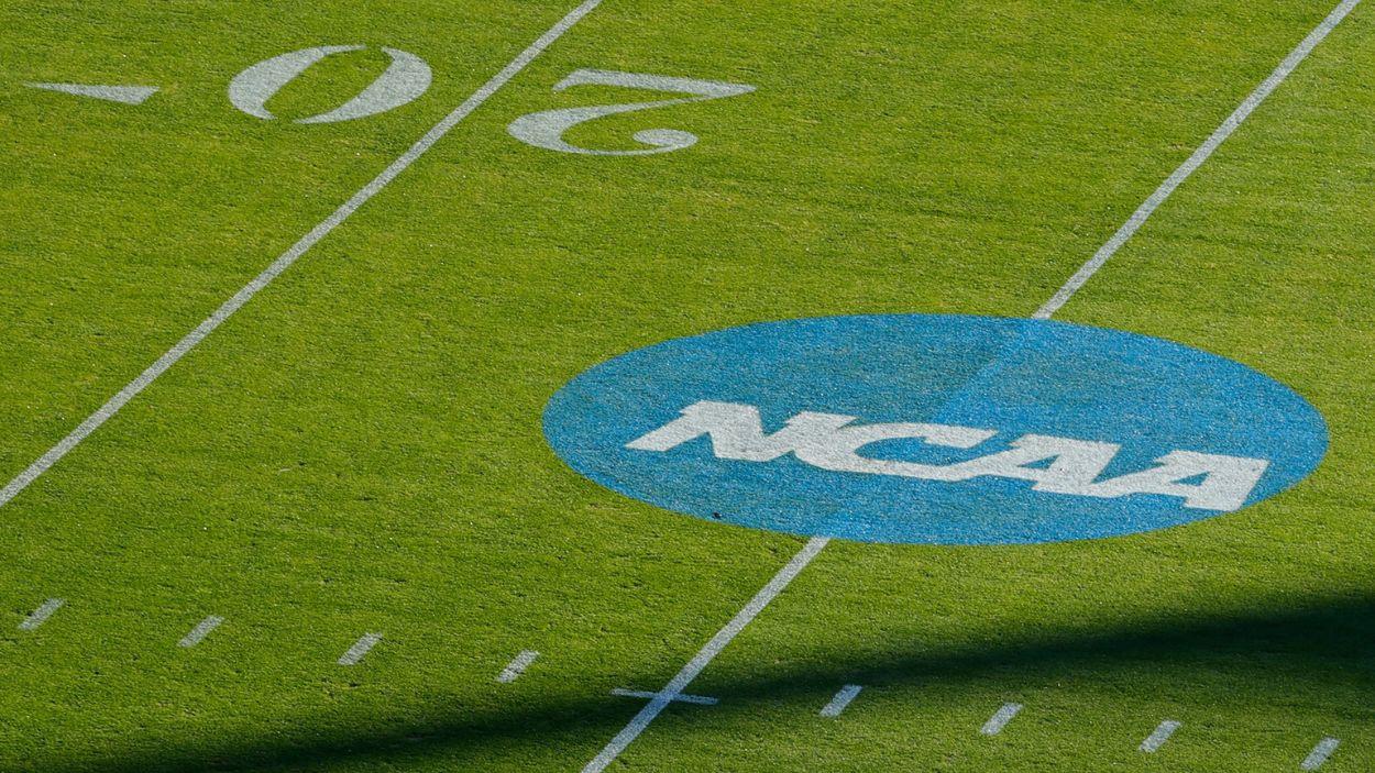 El logo de la NCAA sobre un campo de fútbol americano. Archivo.