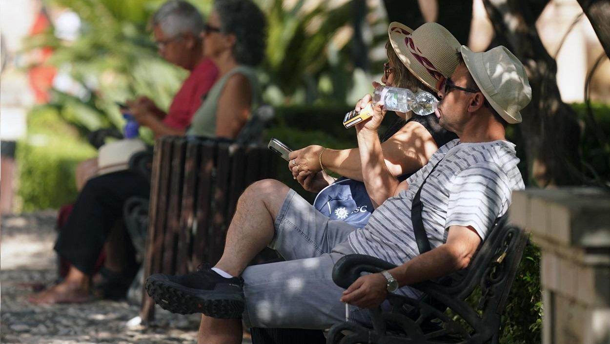Dos personas con ropa veraniega y sombreros. EP