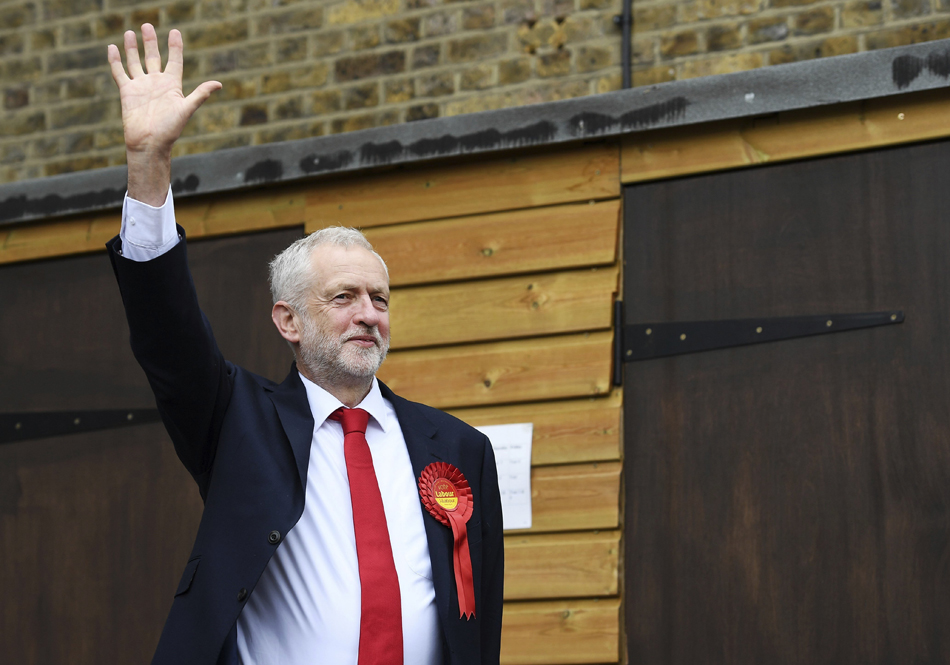 El líder laborista Jeremy Corbyn saluda antes de ejercer su derecho al voto en un colegio electoral en el distrito de Islington en Londres. 