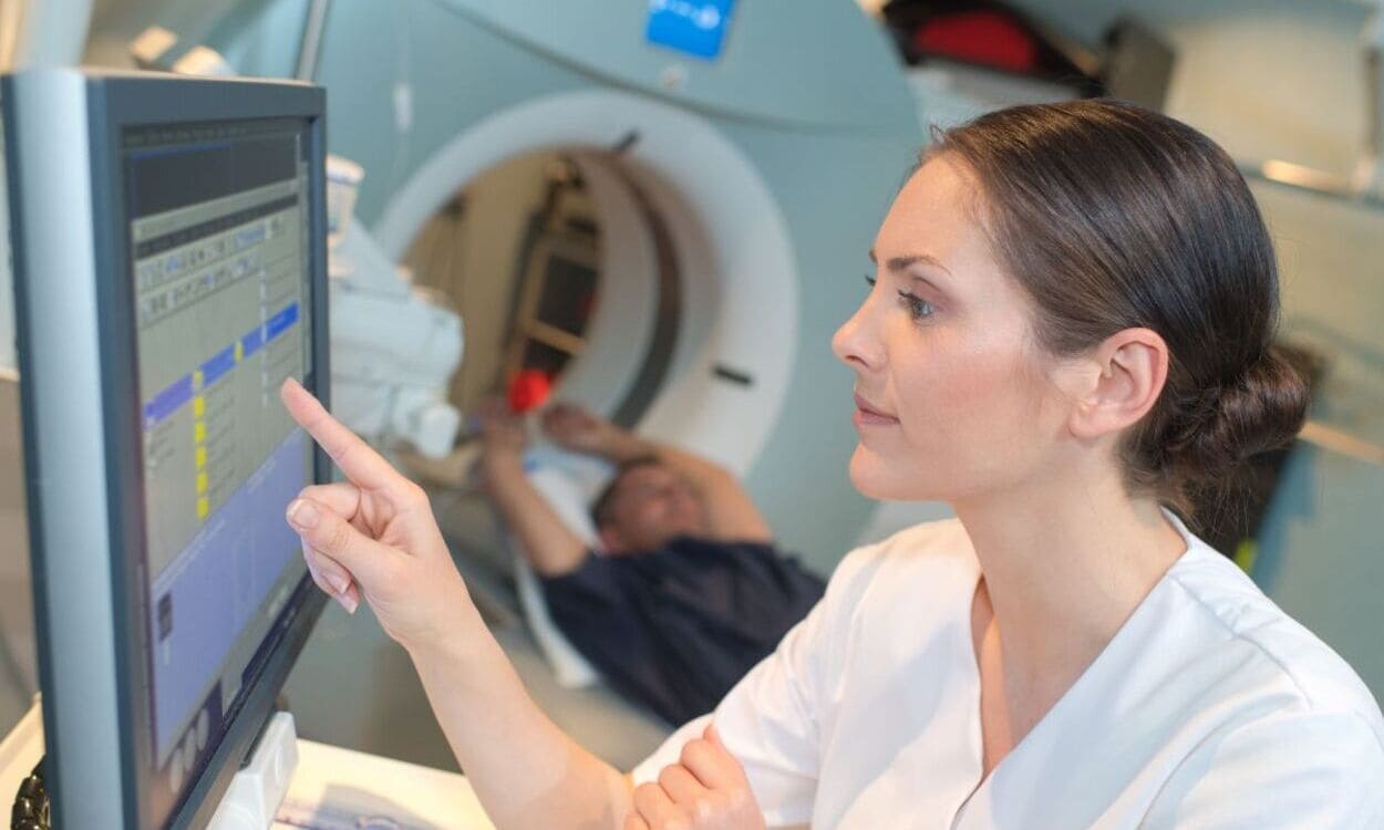 Una sanitaria realiza una resonancia magnética a un paciente | Foto de 123RF/auremar