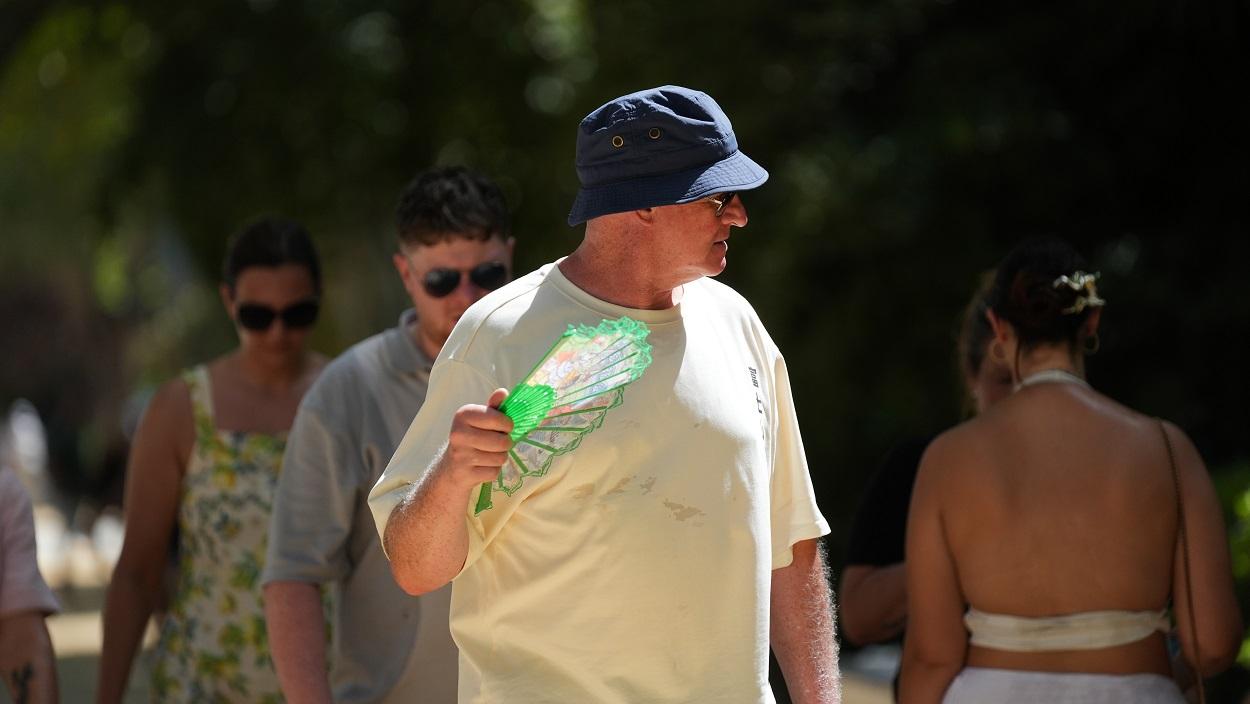 Un hombre con sombrero y abanico durante una jornada de intenso calor. EP