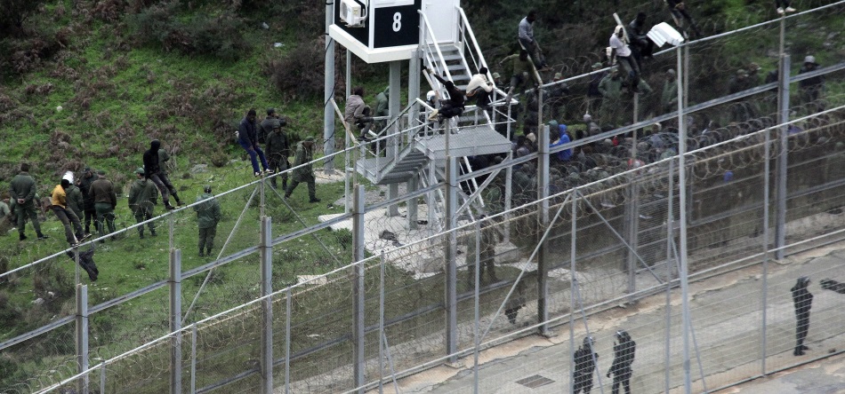 Inmigrantes se suben a la valla fronteriza para acceder a España