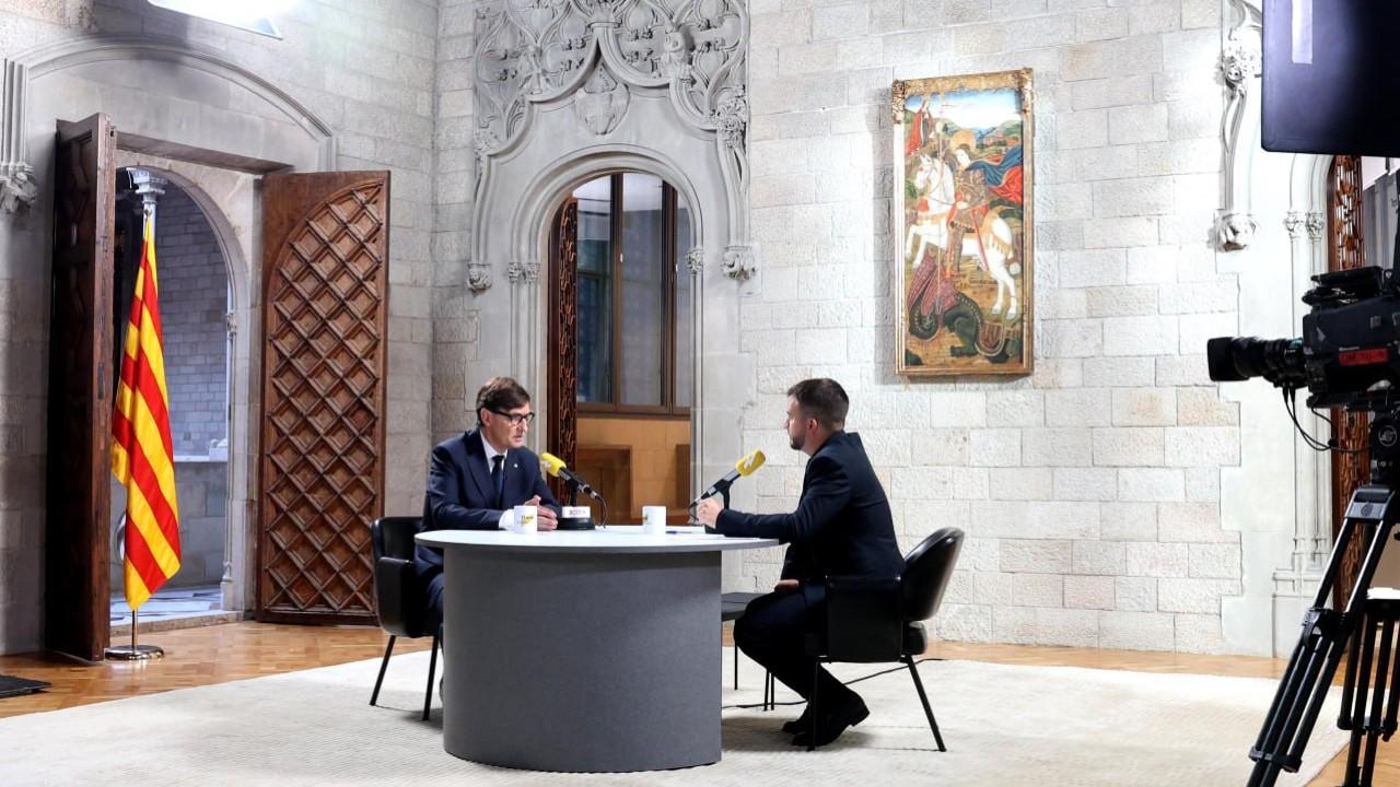 El presidente de la Generalitat, Salvador Illa, con el presentador de Catalunya Ràdio Ricard Ustrell en un momento de la entrevista. Fotografía: Rubén Moreno