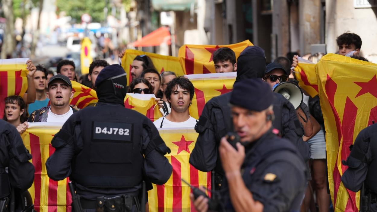Decenas de personas de colectivos antifascistas tras el cordón policial durante una manifestación en protesta por el acto organizado por Aliança Catalana (AC) con motivo de la Diada. EP.