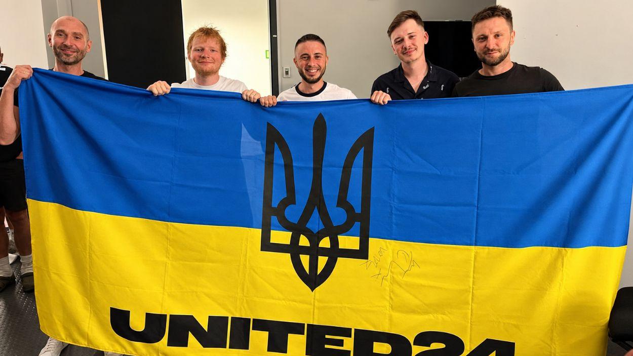 Ed Sheeran y los miembros de Antytila posan con una bandera ultranacionalista ucraniana de UNITED24 para mostrar su apoyo a Ucrania tras su colaboración. (Fuente AntytilaInstagram)